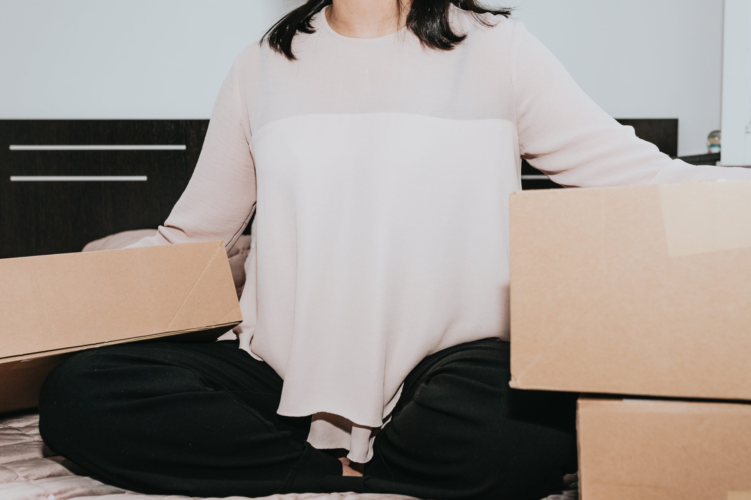 woman sitting with boxes about to commit post-purchase fraud